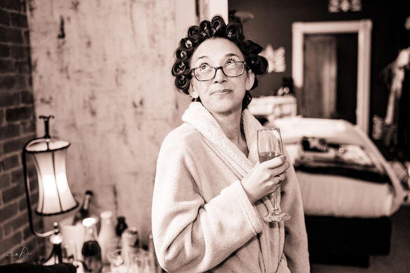 Black and white photo of someone in a robe holding a champagne glass.