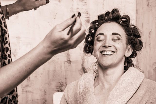 Candid moment during wedding preparation with hair in curlers.