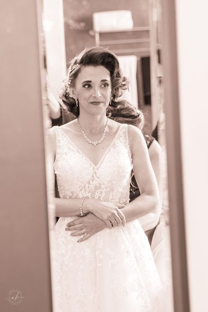 Elegant bridal portrait in vintage style with pearl necklace and lace dress.