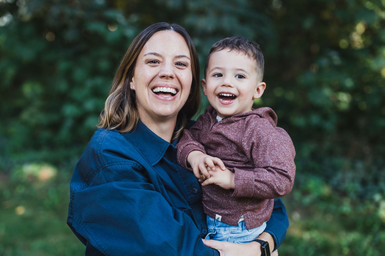 A joyful outdoor moment captured in natural lighting against a green background.