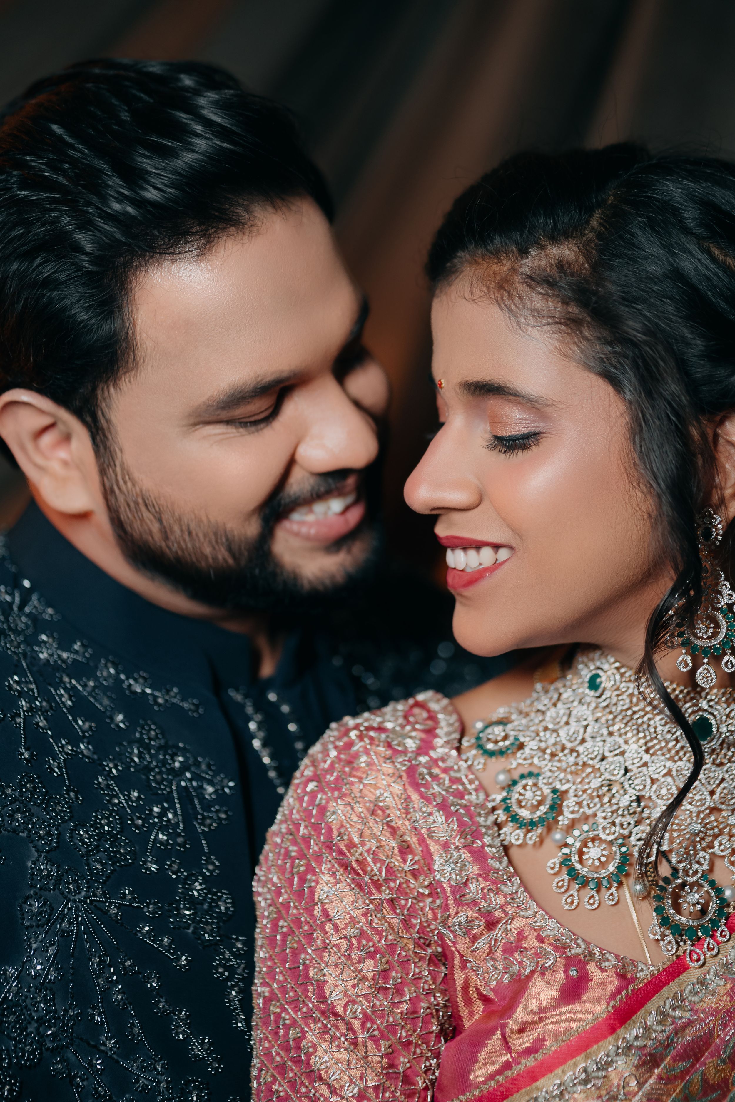A romantic close-up of a couple in traditional Indian wedding attire sharing an intimate moment.