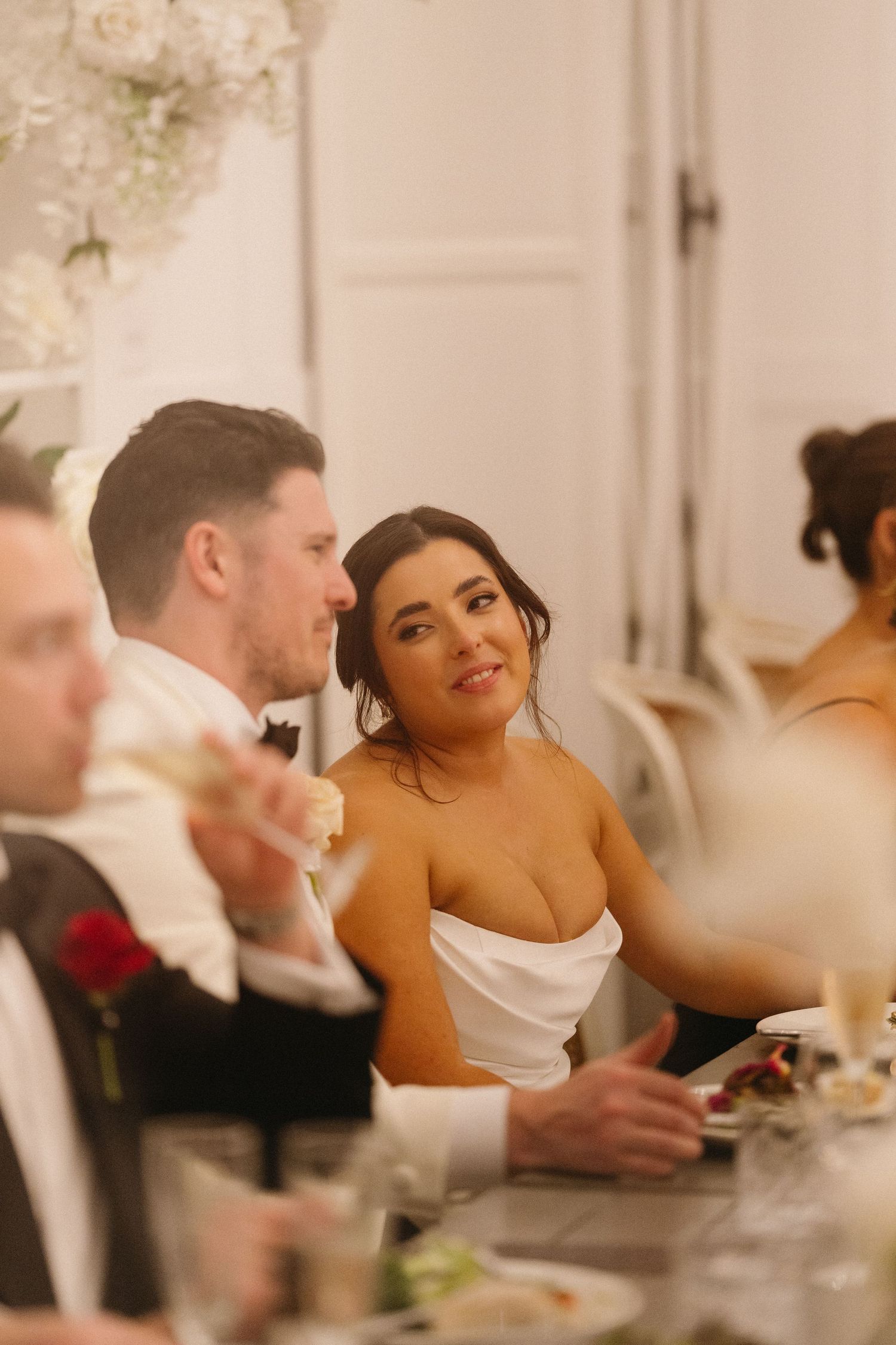 Wedding reception dinner scene with elegant table settings and decor.