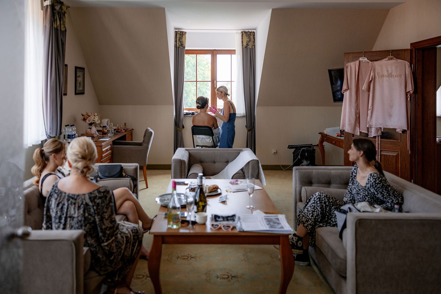Interior room with casual seating and people gathering by a window.