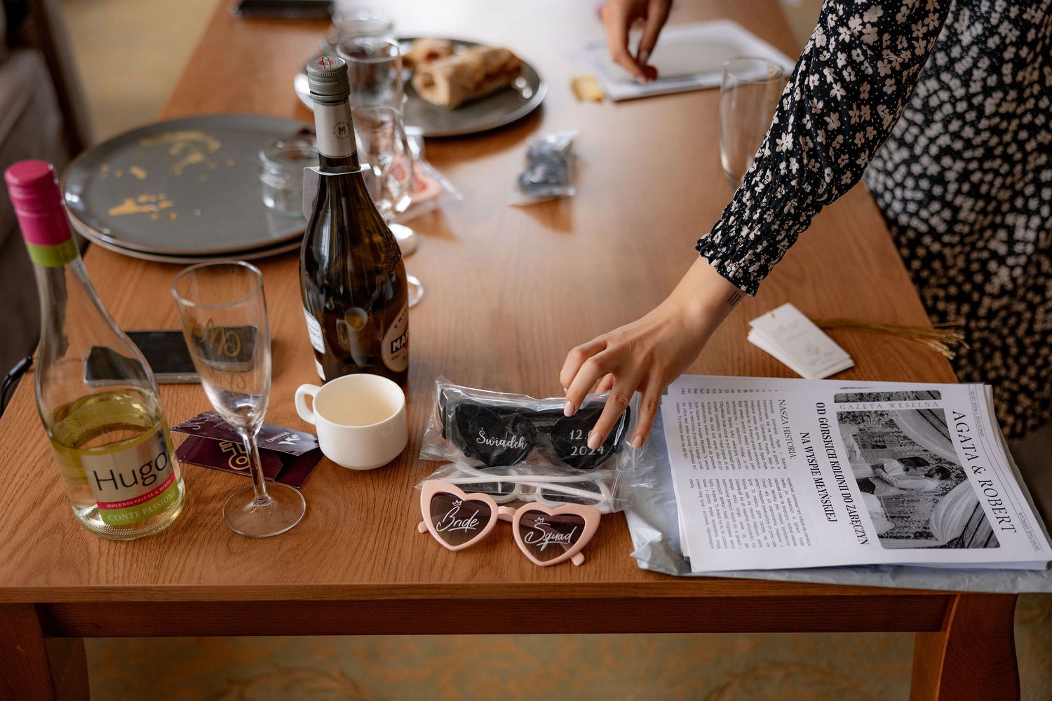 Table setting with wine glasses, newspaper clippings and reading materials in casual atmosphere.
