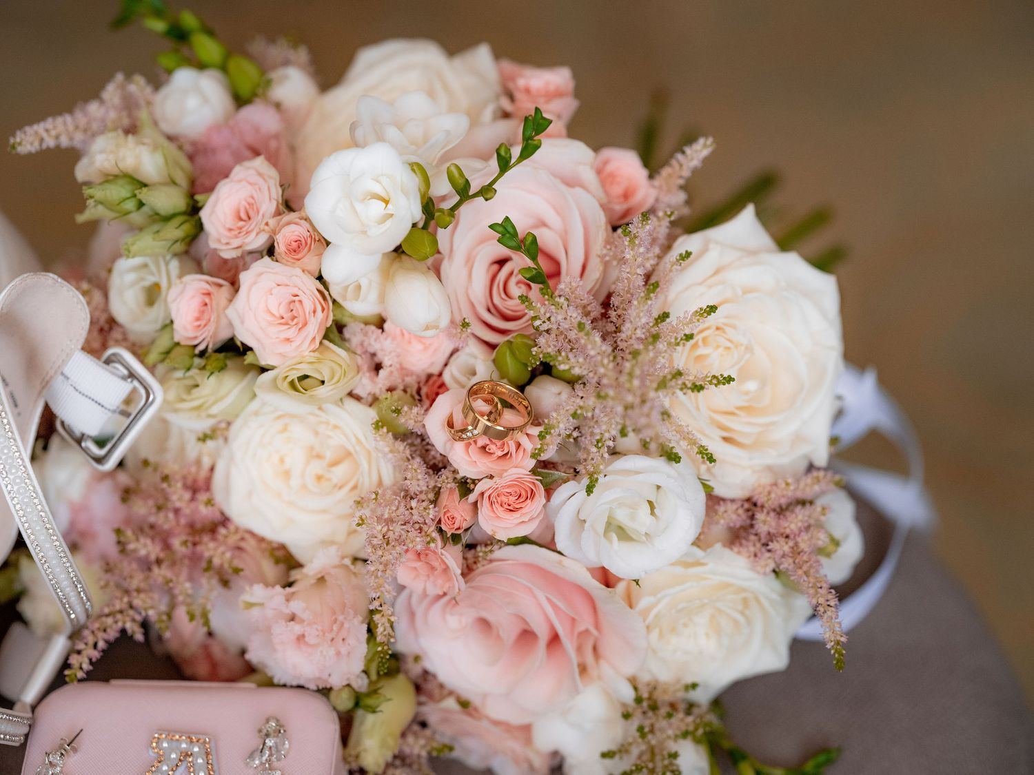 Romantic bridal bouquet featuring pink and white roses with delicate pastel accents.