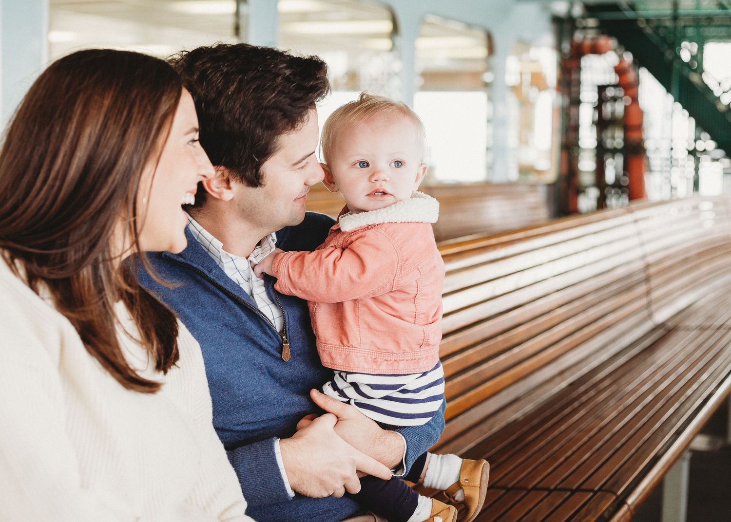 Candid moment of togetherness on wooden benches aboard a passenger vessel.