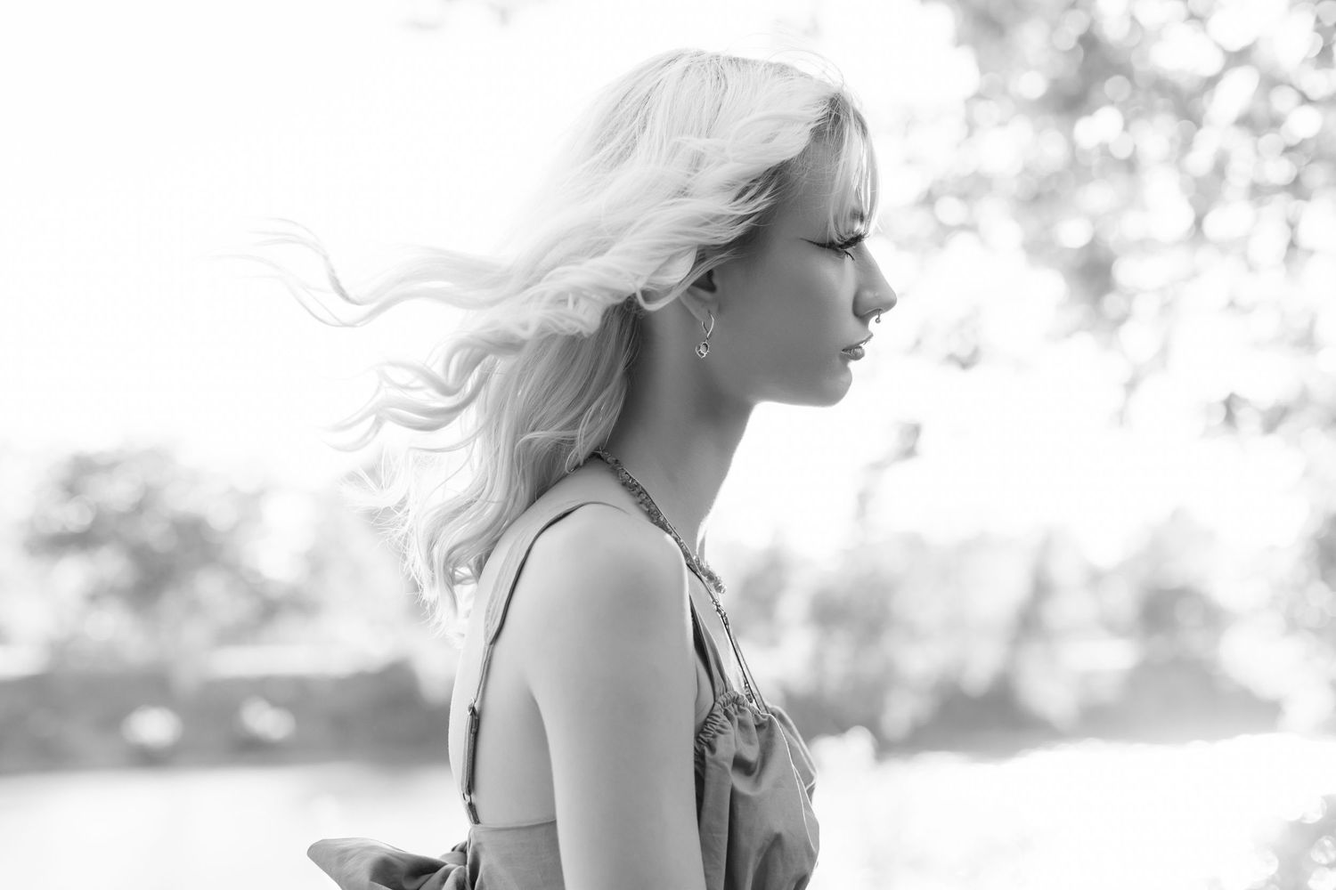 Black and white portrait of a woman with flowing blonde hair in natural lighting.