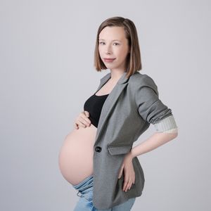 Professional maternity photo of expectant mother wearing grey blazer and black top.