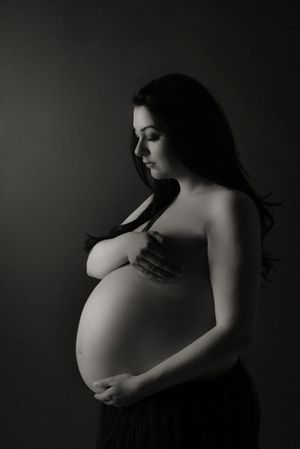 Artistic black and white maternity portrait showing expectant mother's profile.