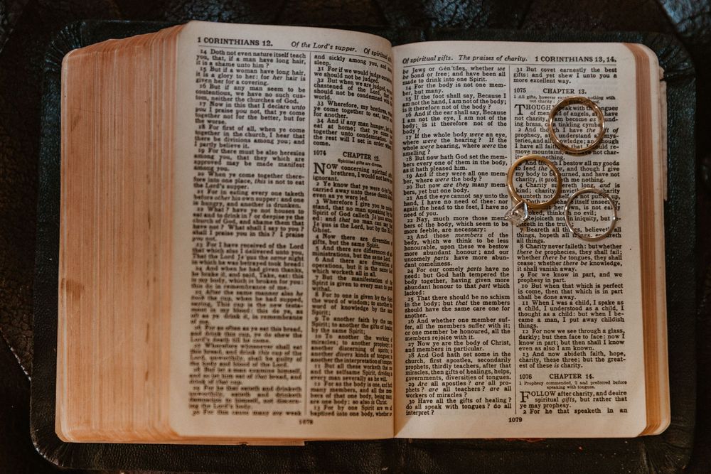 Open Bible with thin pages and small text displayed in natural lighting.