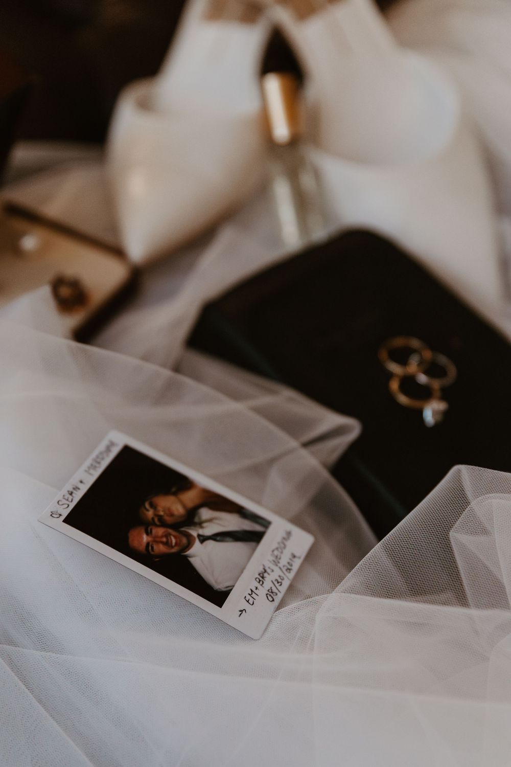Wedding details including rings and cards nestled in delicate white tulle fabric.