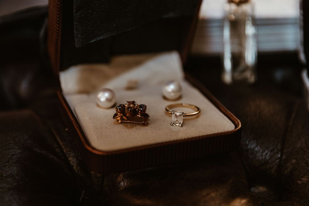 Elegant wedding rings displayed in a vintage brown jewelry box.