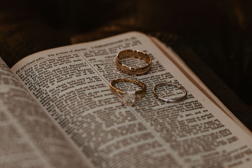 Wedding rings photographed artistically on open pages of a Bible.