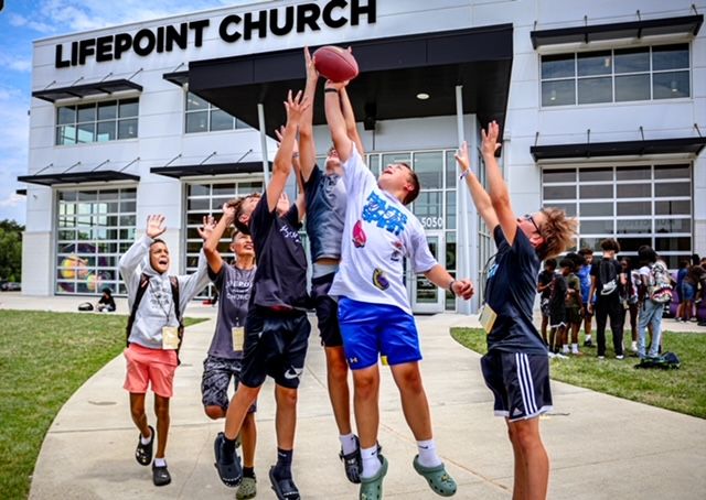 Kids playing football outside Lifepoint Church in Spotsylvania, VA during a vibrant youth conference