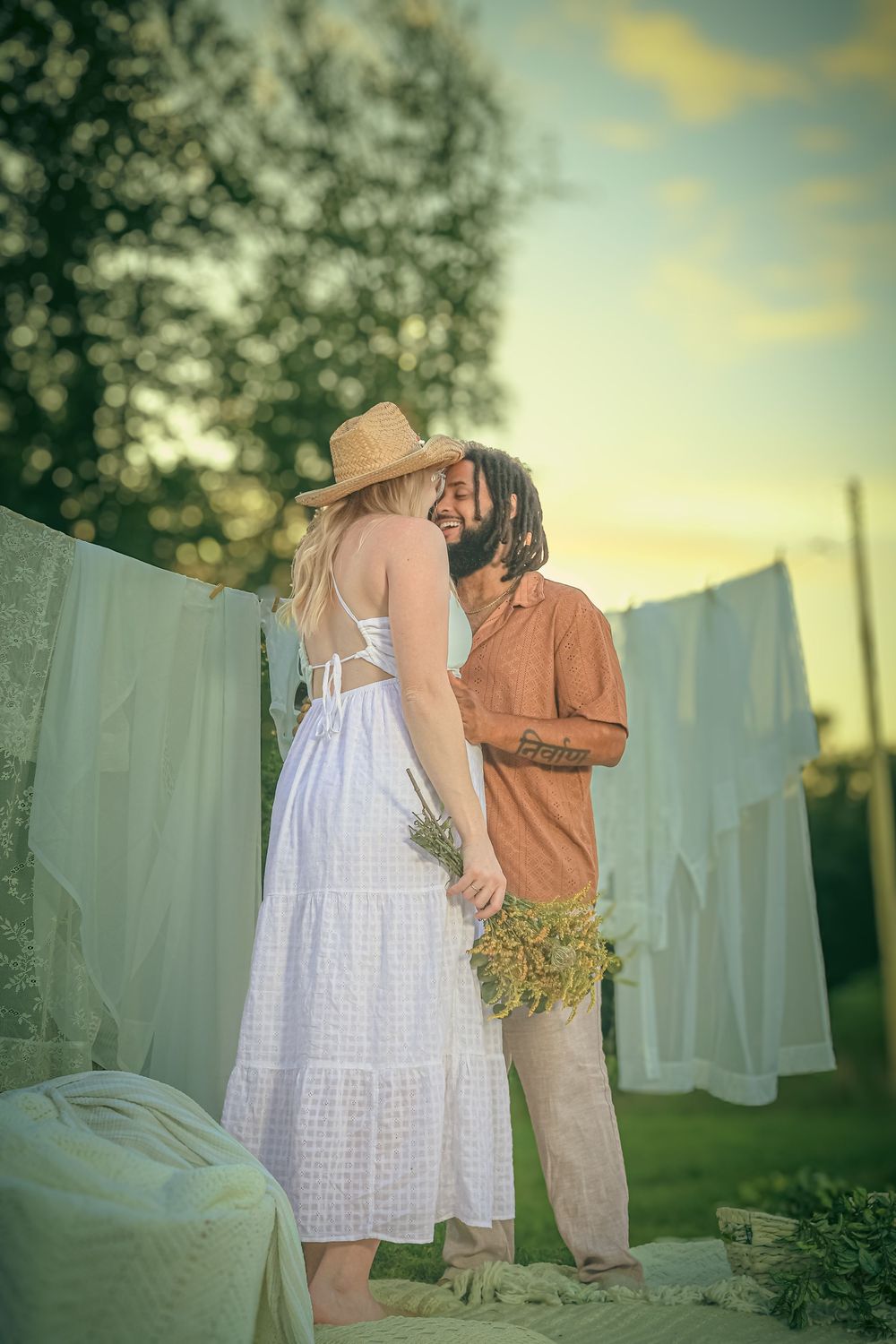Happy couple with their clothesline boho theme maternity photo session in natural lighting in Spotsylvania, VA