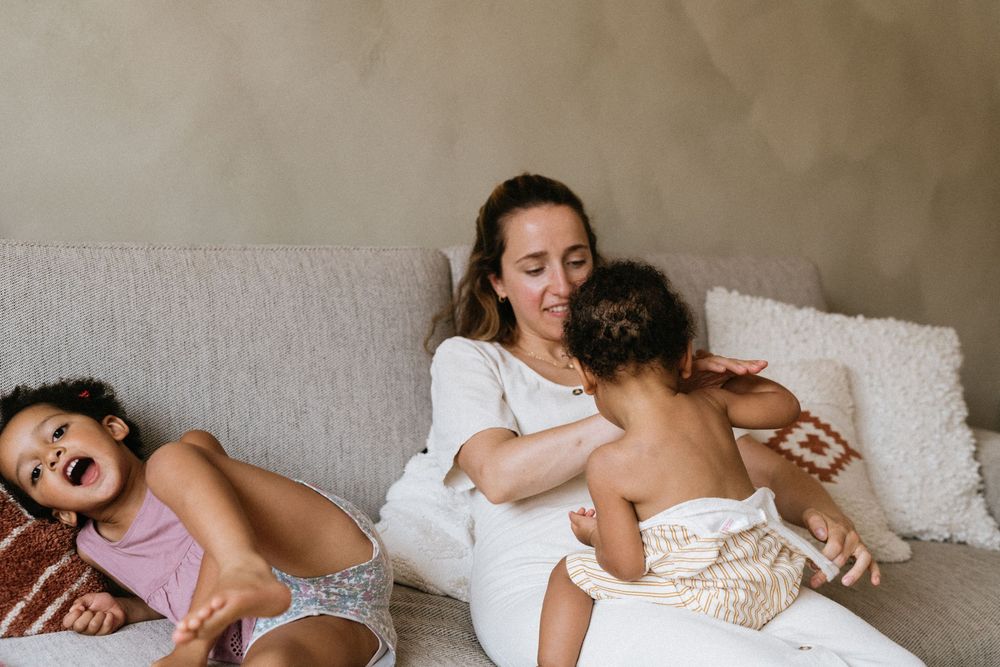 A tender family moment on a cozy gray couch showing intimacy and comfort during quiet time together at home.