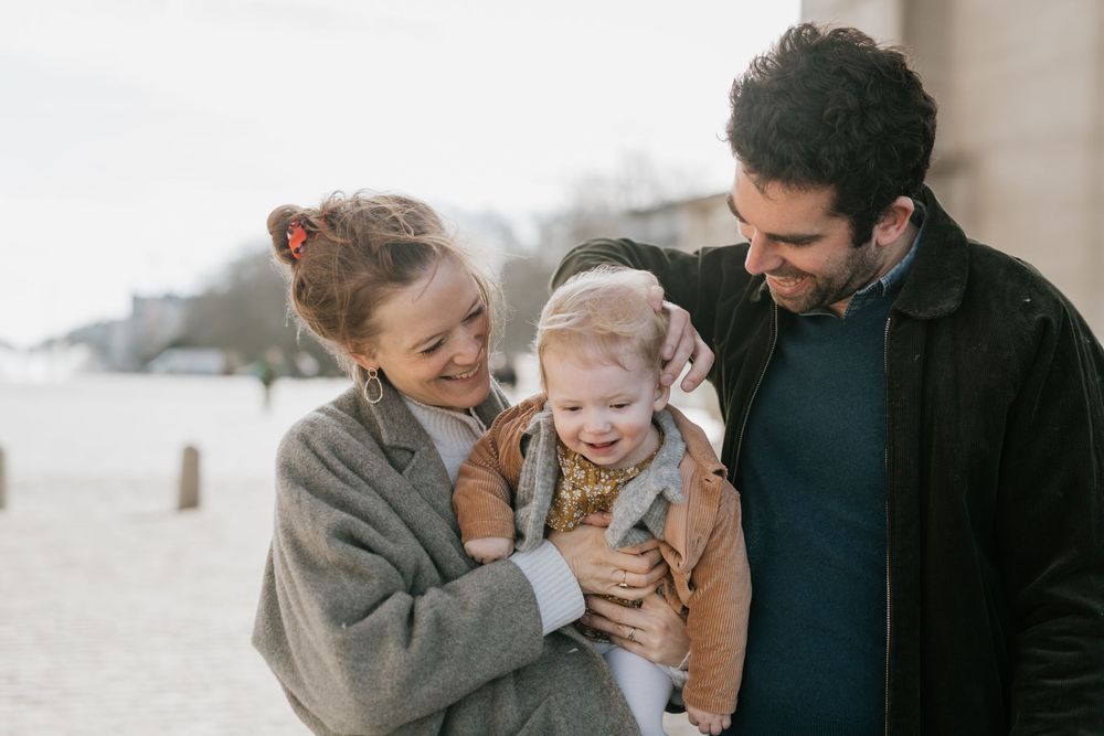 Candid family moment captured on cloudy beach.
