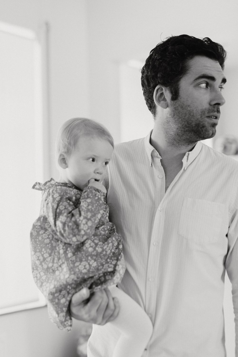 Black and white indoor portrait showing tender parent-child moment.