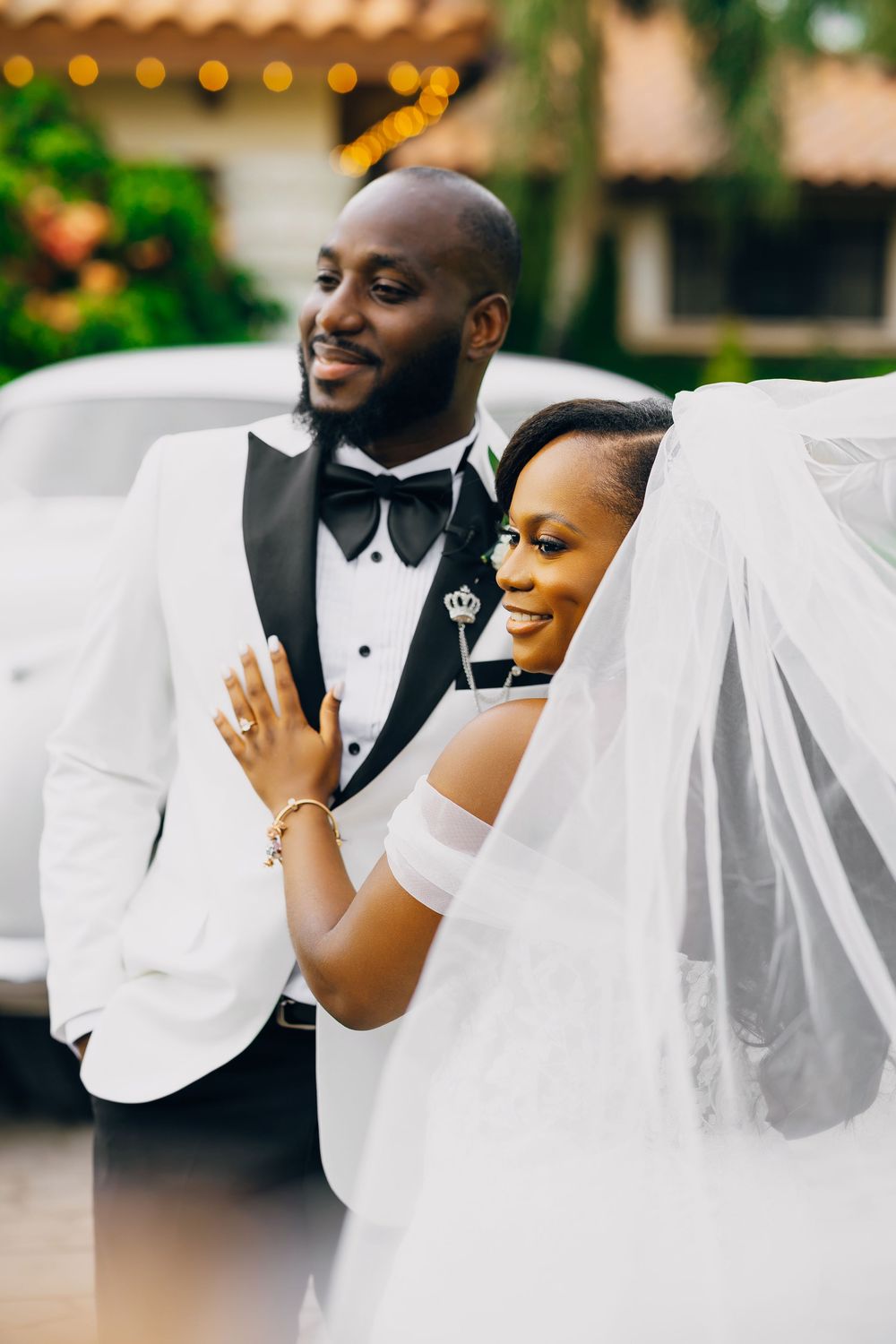A joyful wedding couple in formal attire share an intimate moment together during their outdoor celebration.