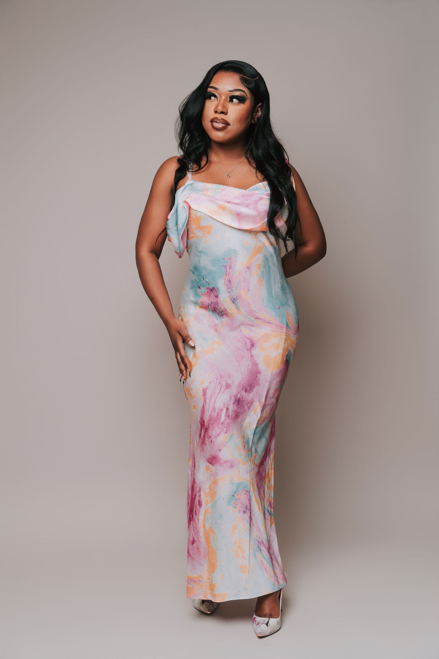 Young woman in a pastel marble-print dress during a light and airy 25th birthday photoshoot at a photo studio in Basildon, Essex