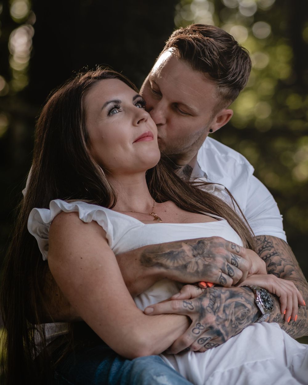 Close-up portrait of couple embracing outdoors with soft natural lighting.