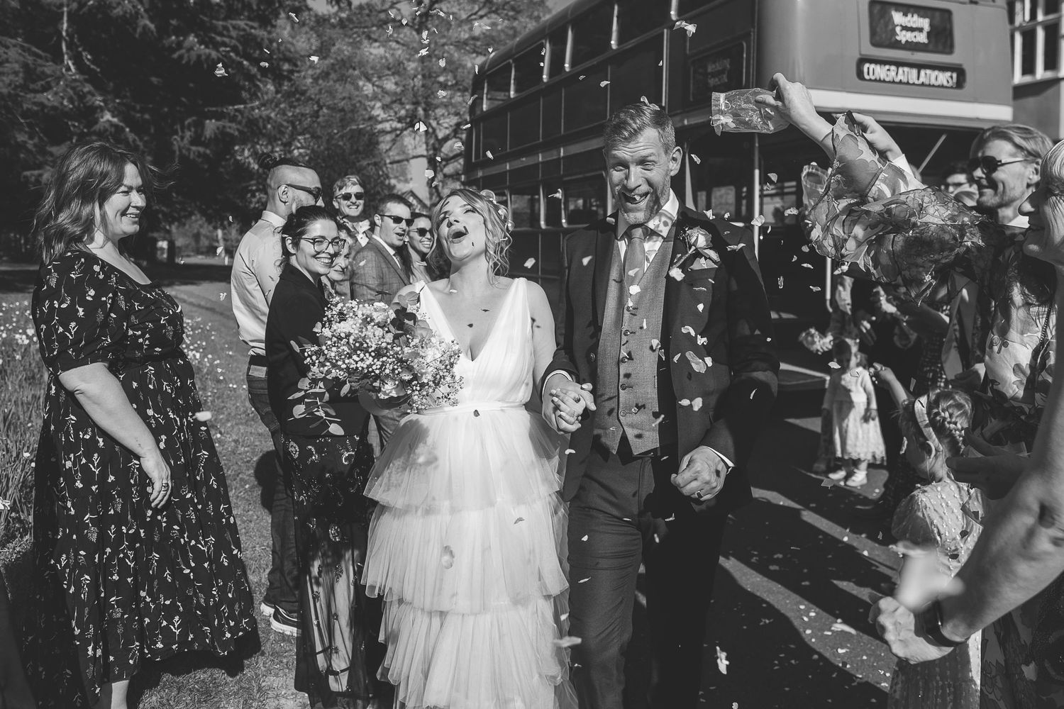 Wedding guest sitting on the bus with celebratory glasses of champagne in hand