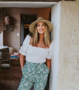Self portrait of Lauren Christine Parker standing in a doorway in the South of France. She is wearing a stylish outfit.