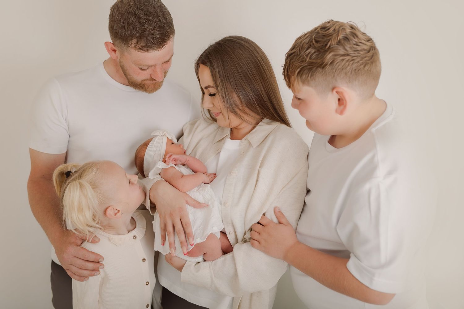 Family portrait session with coordinated white outfits against neutral backdrop. Photographer. Hull. East Yorkshire. Photography