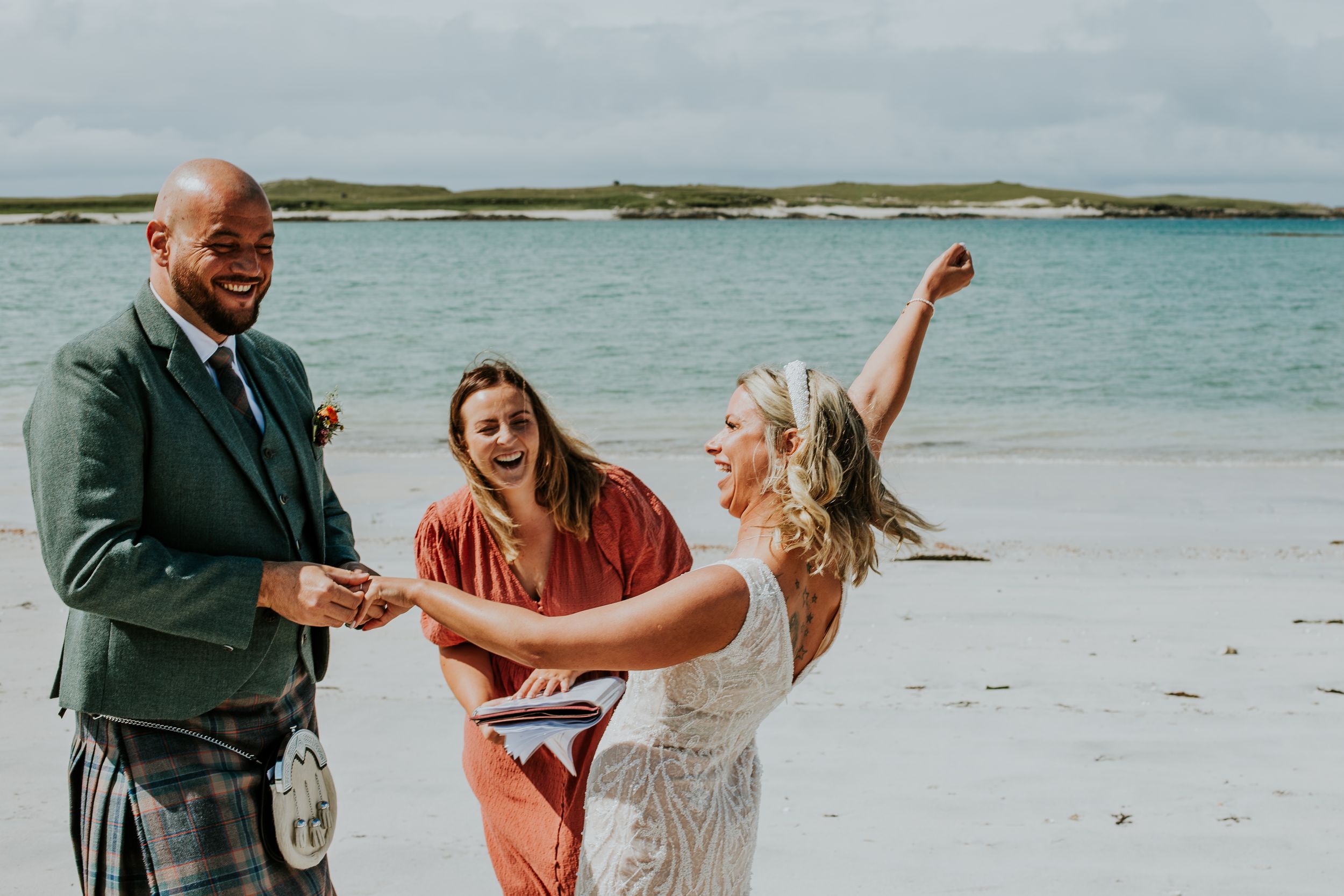 A joyful celebration on a beach with people dancing and laughing together.