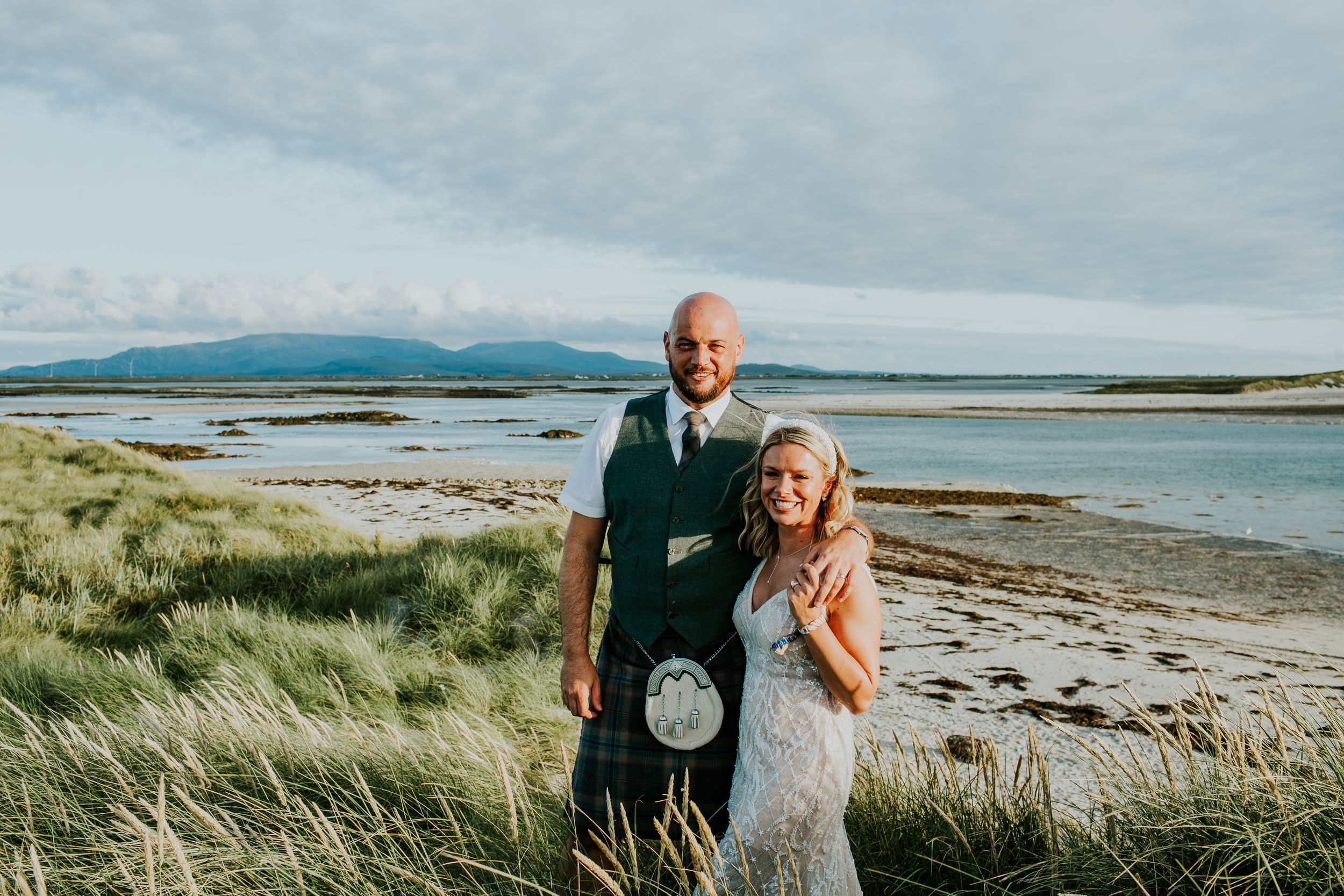 Coastal wedding photography on a Scottish beach with dramatic landscape views in the background.