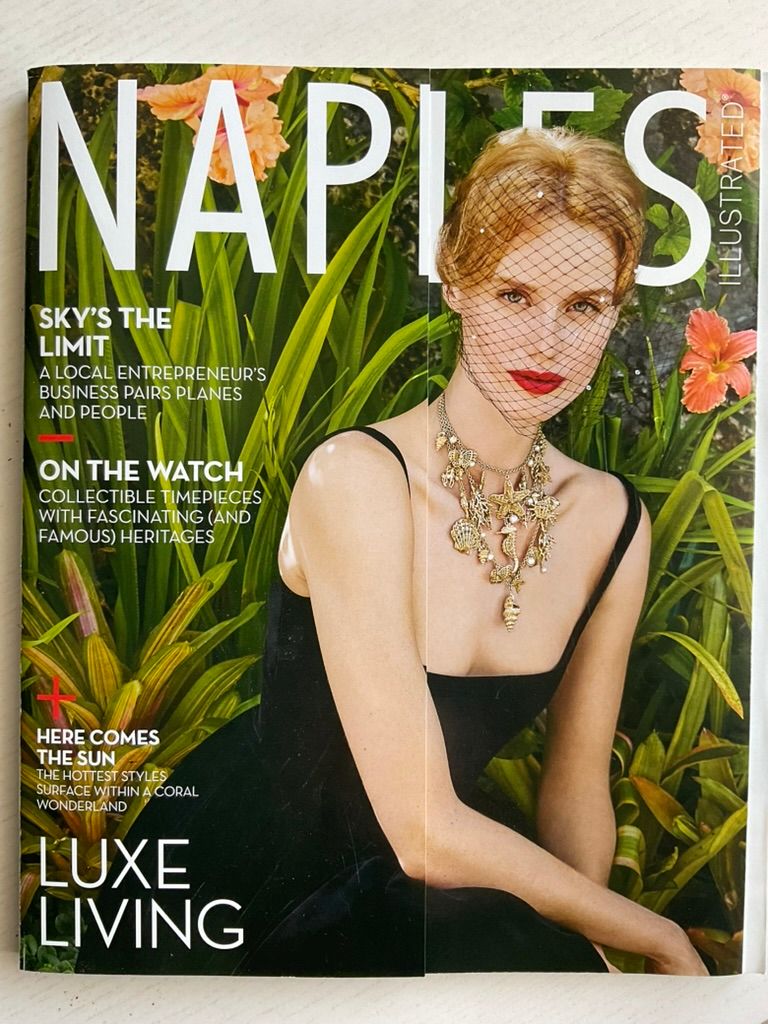Cover of Naples Illustrated magazine featuring a woman in black dress with ornate necklace and veil among tropical foliage.
