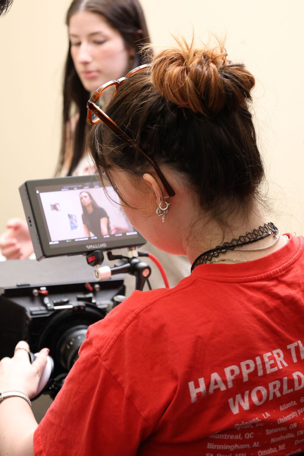 Film crew wearing red shirts operates professional video cameras during a production shoot.