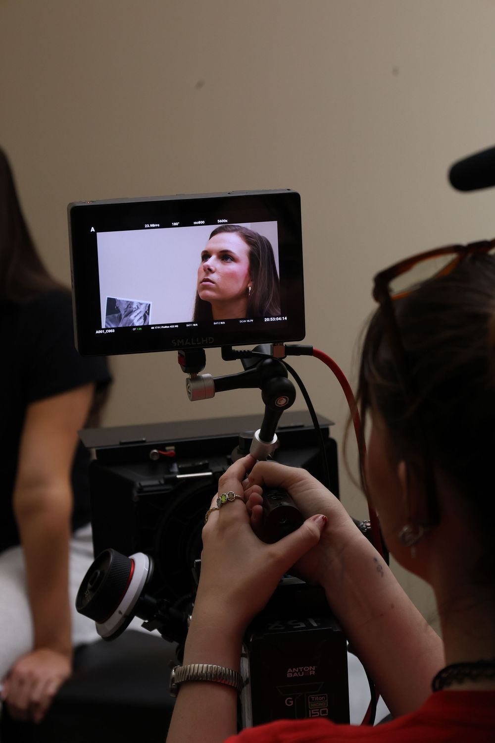 Camera operators frame shots using professional video equipment in a studio setting.