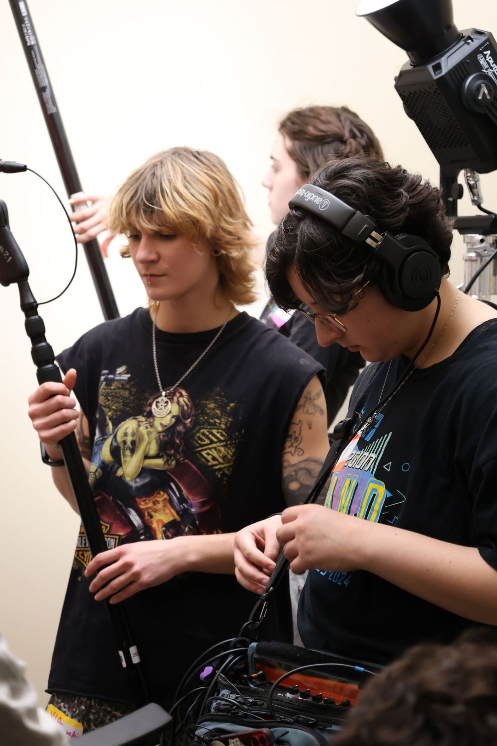 A group of gamers wearing headphones and holding gaming controllers while playing together in a row.