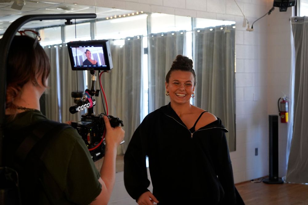 A sequence of six images showing someone filming with a handheld camera in an indoor setting with curtained windows.