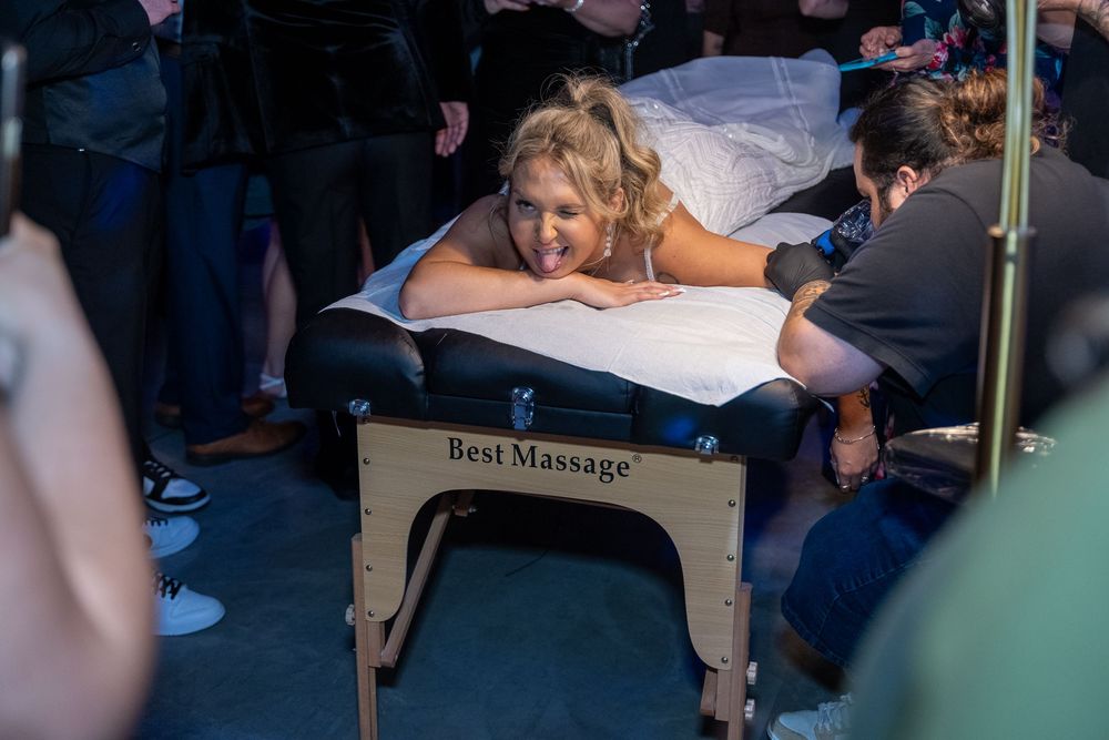 A person receives a relaxing massage on a portable massage table at an outdoor event.