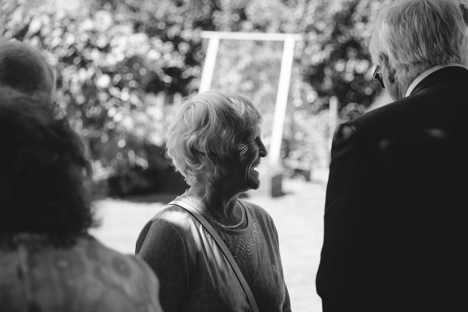 A woman looking into the distance between two friends at a Vancouver wedding.