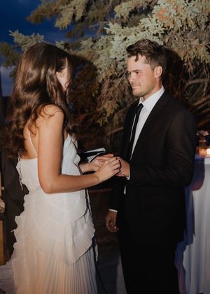 bride and groom exchange rings during intimate elopement at night time flash wedding photography editorial style Moncton wedding photography