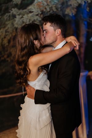bride and groom's first kiss during night time outdoor wedding ceremony, flash photography, candid documentary style wedding photographer