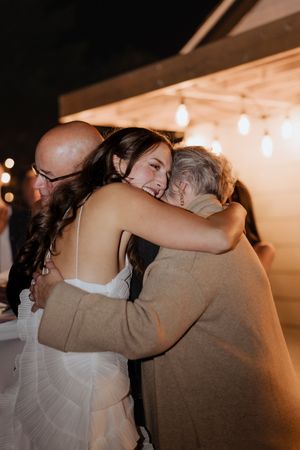 Bride hugs her parents during surprise wedding at an intimate night time wedding elopement in Moncton New Brunswick wedding photographer