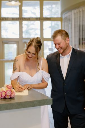 Couple sign marriage certificate in fall elopement micro-wedding photographer in New Brunswick Canada photographer near Moncton NB