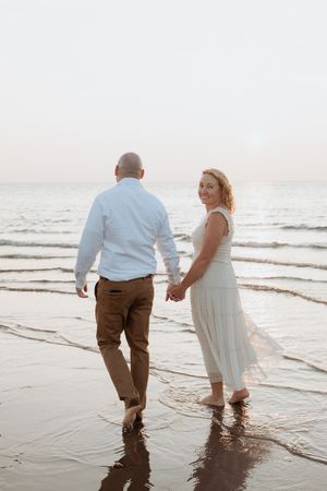 Couple walk hand in hand at sunset in New Brunswick wedding photography packages, Canadian wedding photography Alma NB wedding elopement