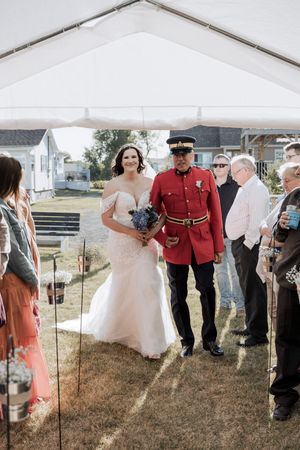 bride walks down the aisle in an outdoor summer tent backyard wedding in Bouctouche New Brunswick, Cocagne wedding photographer packages