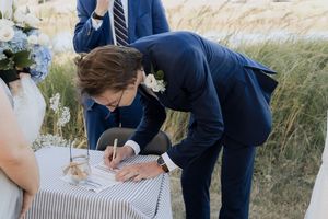 groom signs marriage certificate in intimate microwedding at Parlee Beach, Shediac elopement photographer Moncton New Brunswick, summer