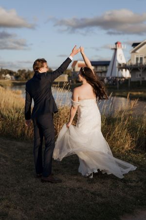 Bride and groom dance at sunset infront of a lighthouse, beach sunset wedding photography in New Brunswick, Moncton photography elopement