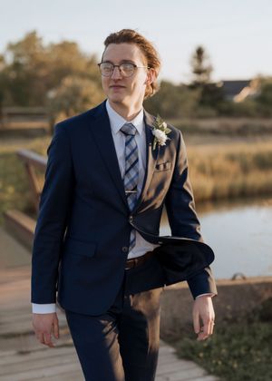 Groom walks across a bridge, Parlee beach elopement photography, sunset beach wedding photography in New Brunswick wedding photographer