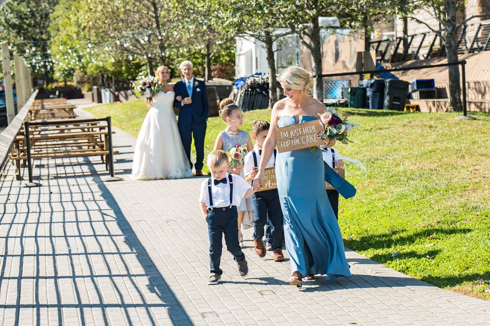 Wedding party walking down a stone path in a garden setting during an outdoor celebration.