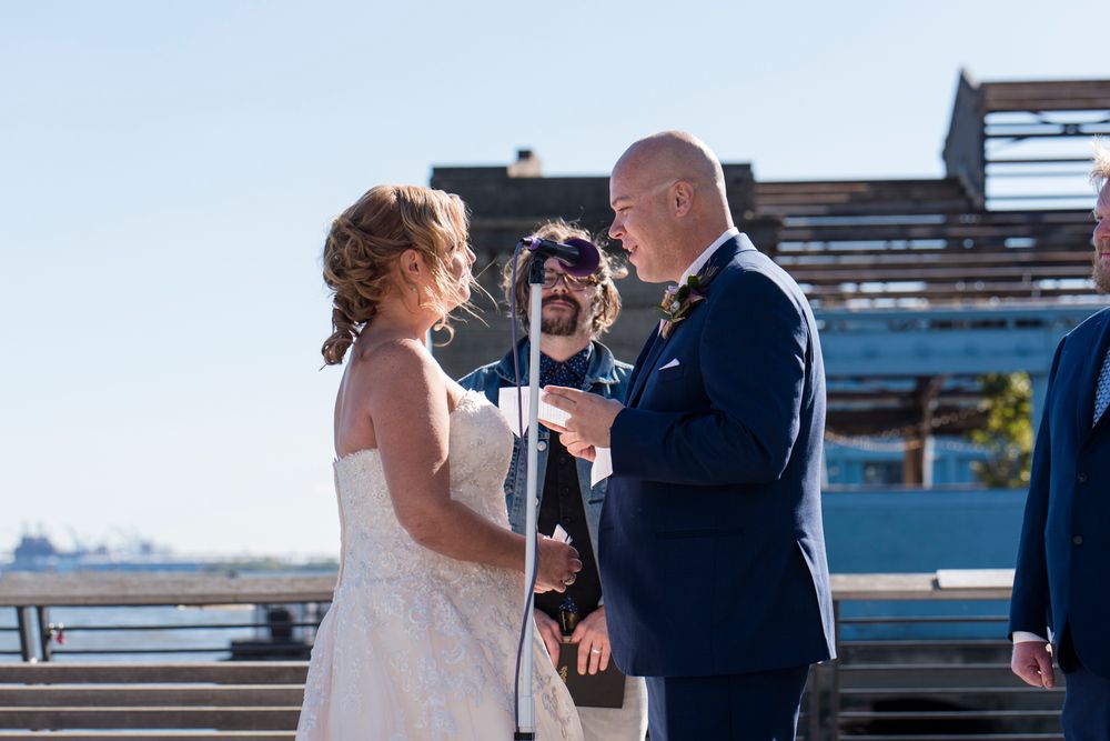 Couple shares an intimate moment during their outdoor wedding ceremony at a sports stadium venue.