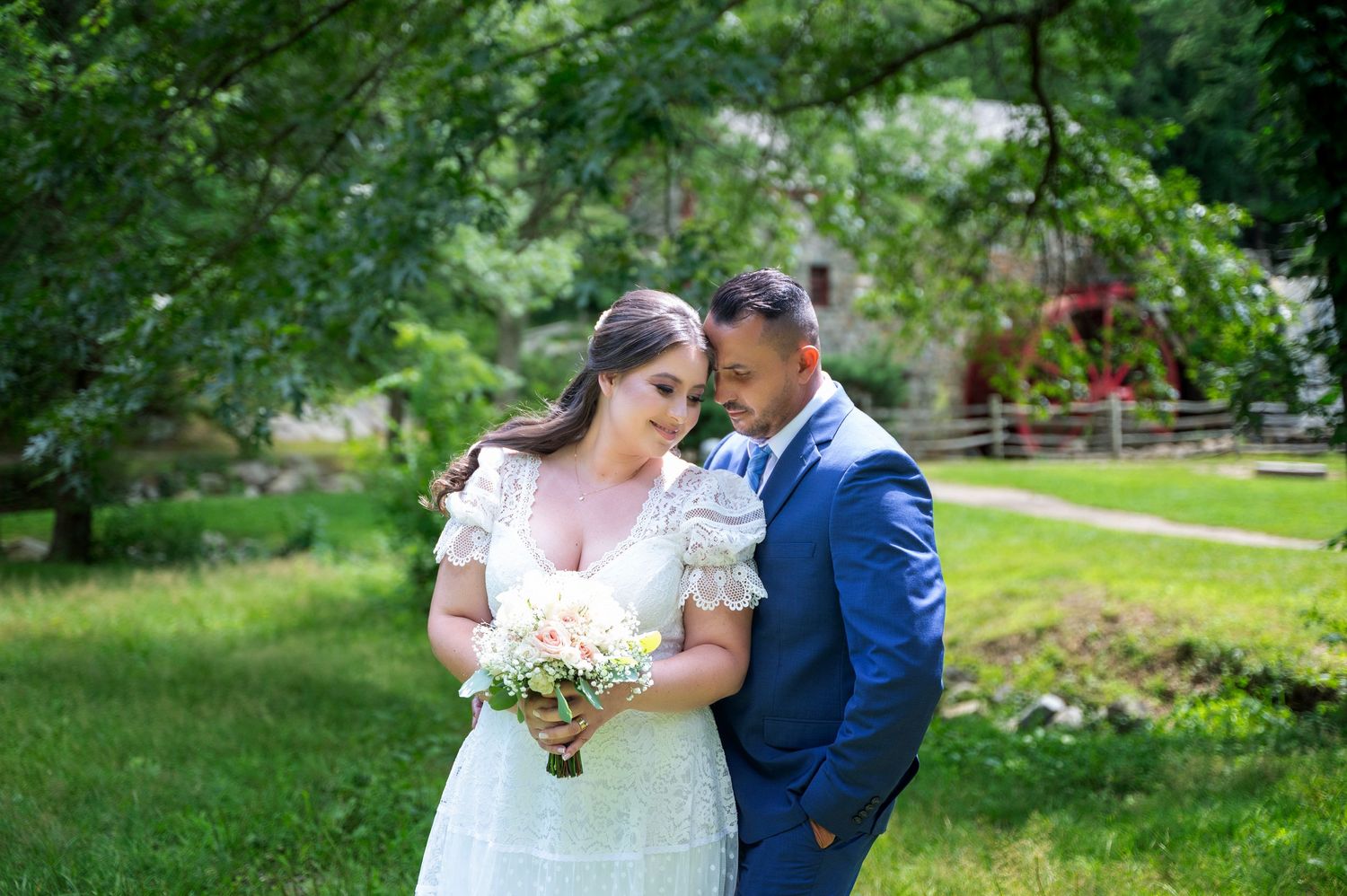 A wedding couple shares an intimate moment in a lush garden setting.