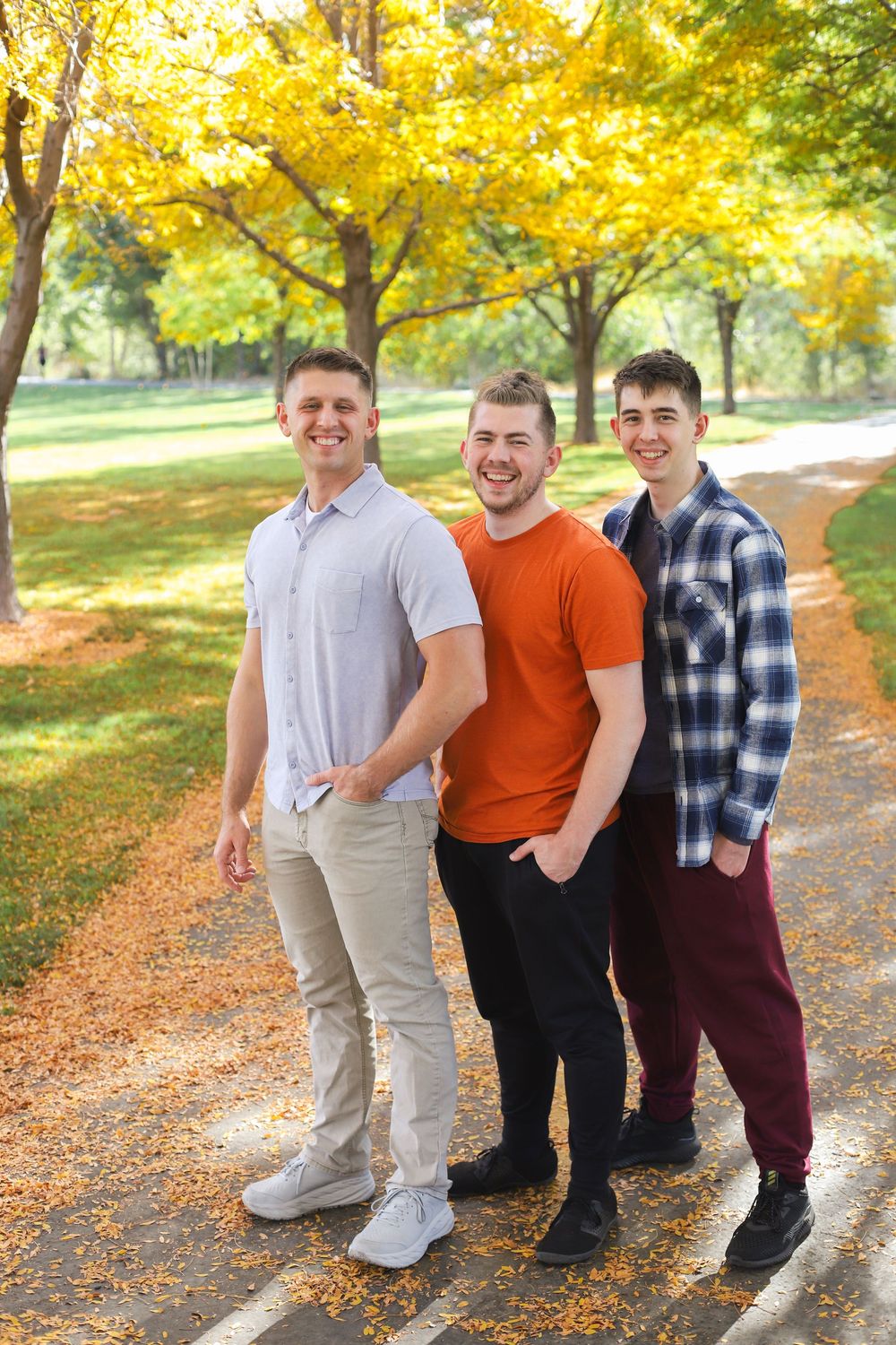 A group sits together on stone steps surrounded by vibrant yellow fall foliage in a park setting.